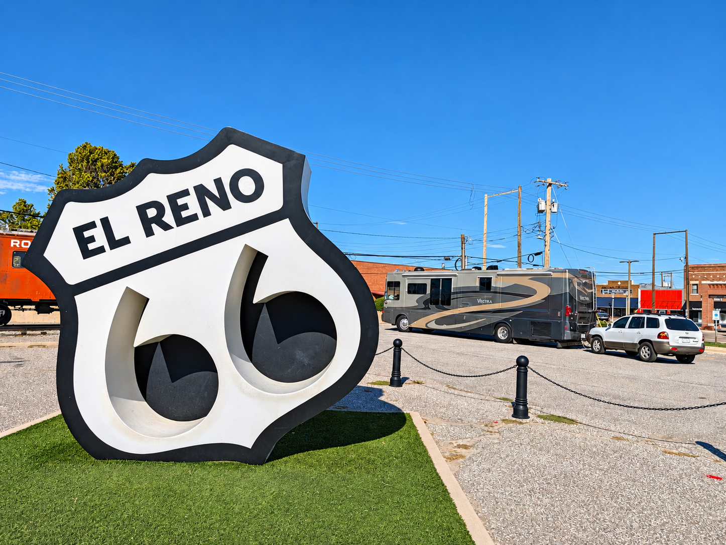 Large El Reno Route 66 shield sculpture with the Vectra and Santa Fe parked behind it