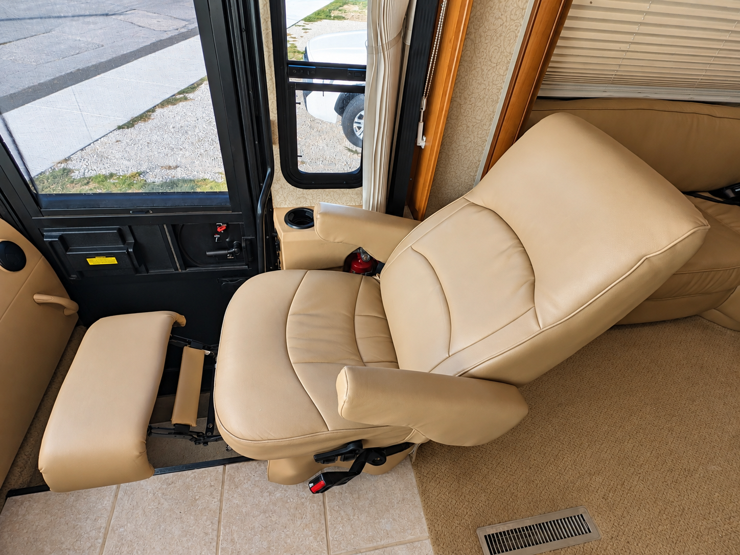 Tan leather passenger captain's chair reclined with footrest extended