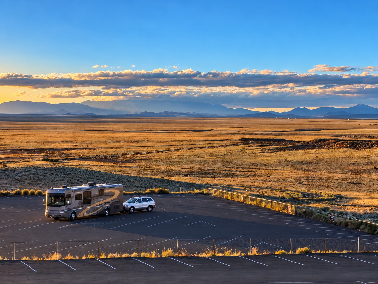 The Vectra and Santa Fe hitched together in a desert parking lot at sunset
