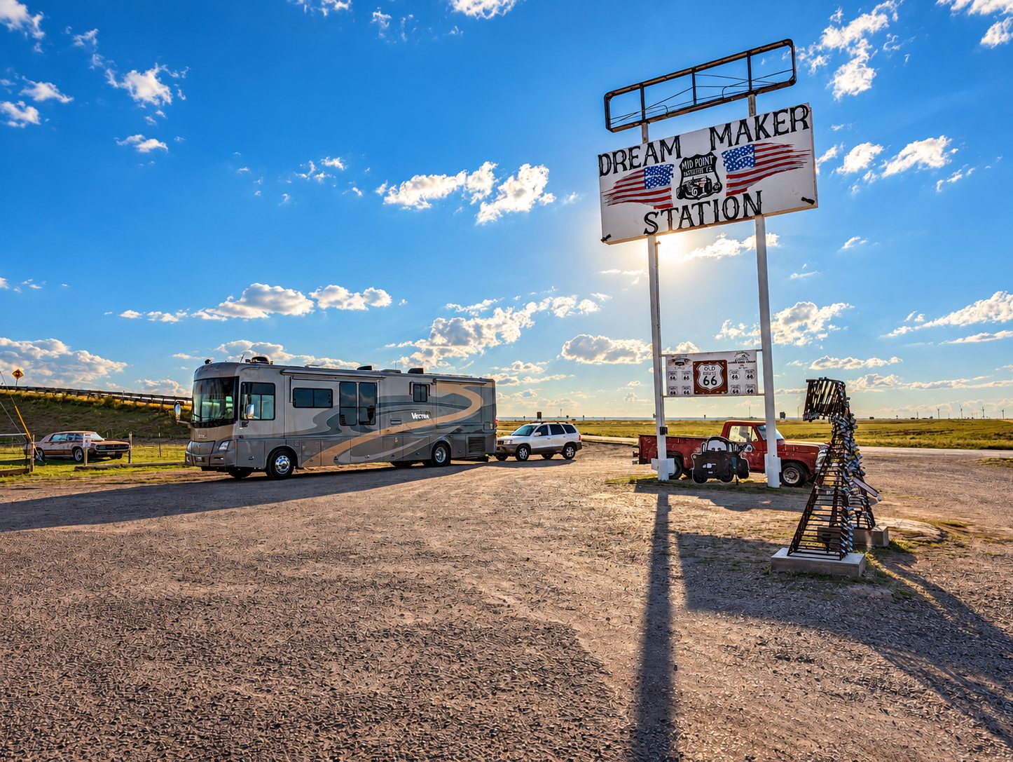 Winnebago Vectra and Santa Fe parked beneath the Dream Maker Station mid-point Route 66 sign in Adrian, Texas, beside a metal sculpture covered in padlocks
