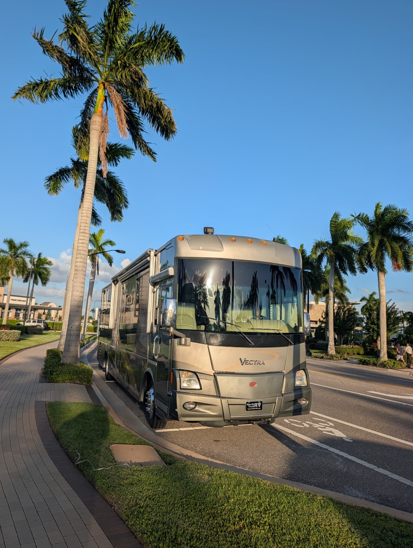 Winnebago Vectra front view parked beside palm trees