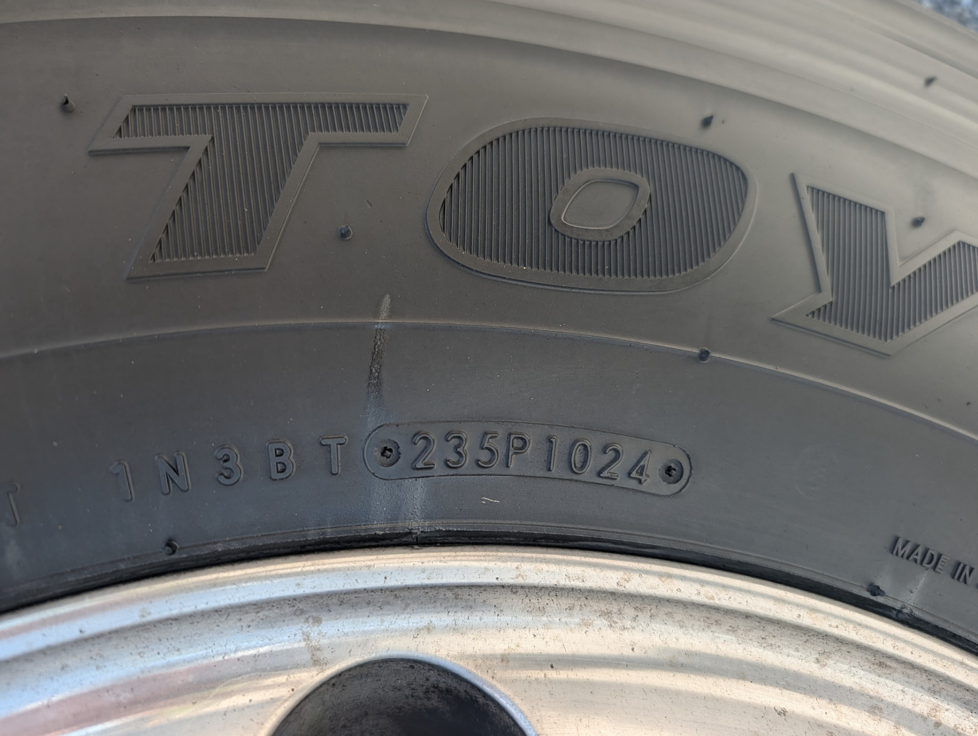 Close-up of a tire sidewall DOT date code 1024 on a second tire